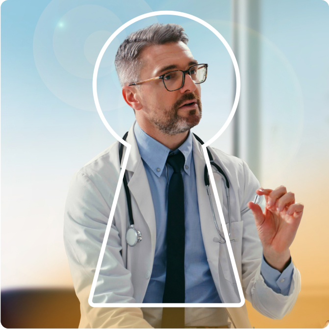 Male physician holding the Revi device between his fingers while talking to patient out of view.
